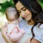 dreamy young mommy holds her little daughter posing outside scaled